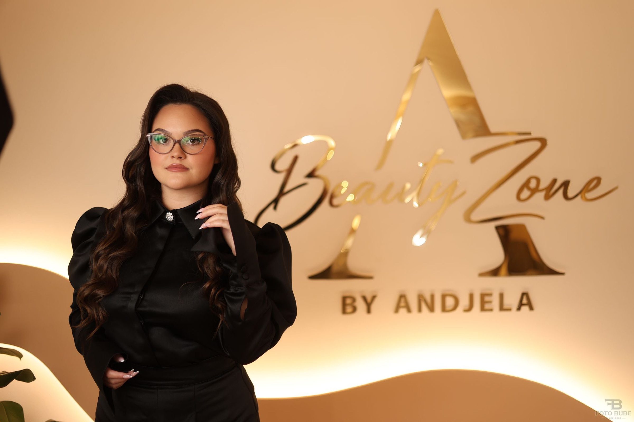 Anđela, osnivačica salona Beauty Zone by Andjela, ispred zlatnog logotipa salona